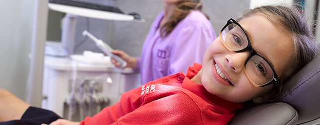 Photo of a relaxed and smiling young girl in dental chair